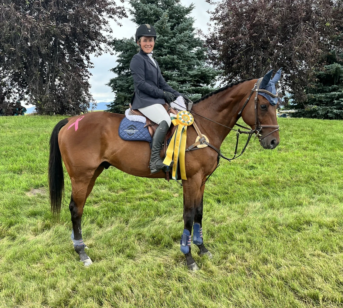 Smiling rider atop a brown horse